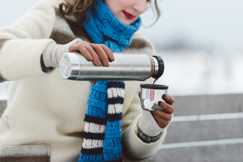 Woman pouring hot chocolate from vacuum flask